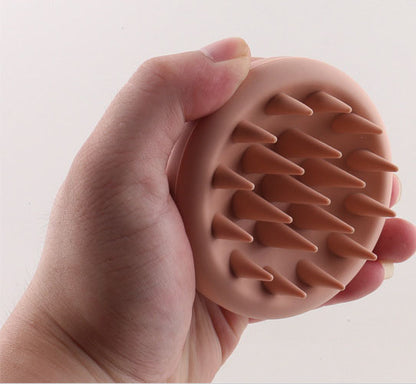 Hand demonstrating the flexible silicone scalp brush bristles