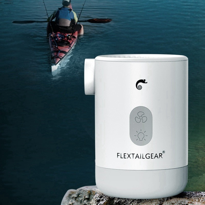 White mini air pump beside water with a kayaker in the background