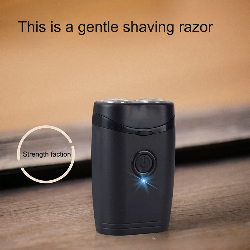 Compact black rotary shaver standing on a wooden surface