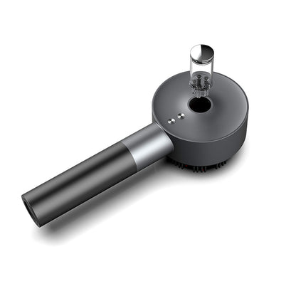 Gray scalp brush with a bottle shown above its applicator opening