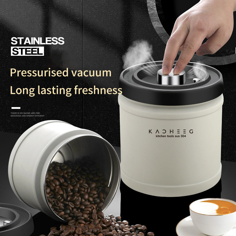 Vacuum storage canister with its lid button being pressed beside coffee beans