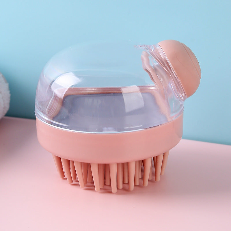 Pink shampoo brush with clear reservoir and round dispenser button