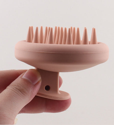 Side view of the silicone scalp brush showing its bristles and finger grip